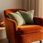 Warm living room corner with a burnt orange velvet accent chair, terracotta ceramics, and natural wood accents under golden light